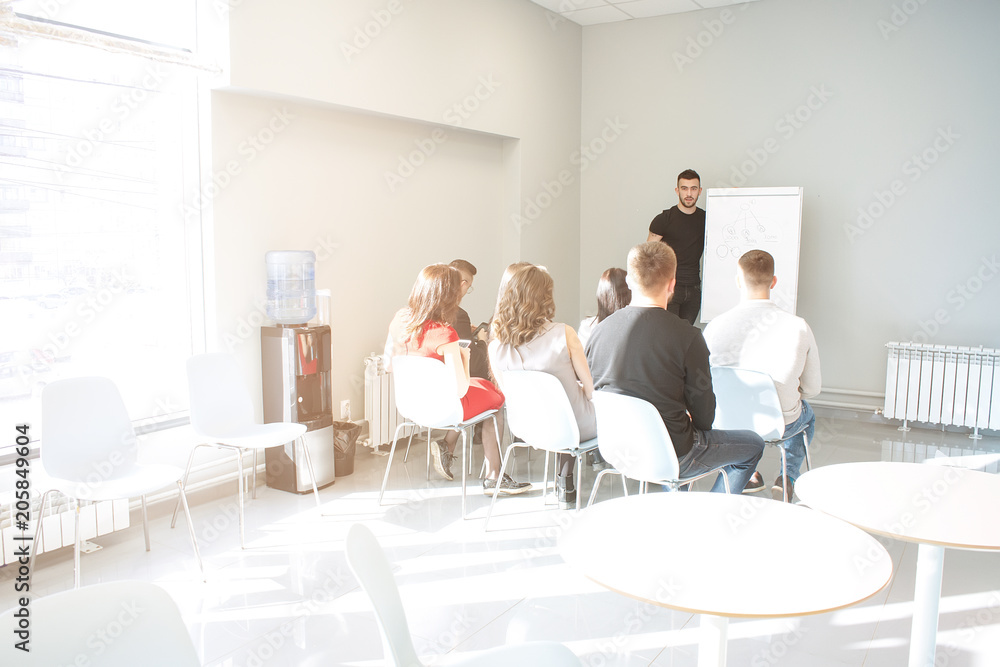 Take a look at our results! Handsome young man in glasses standing near whiteboard and pointing on the chart while his coworkers listening and sitting at the table Take a look at our results! Handsome young man in glasses standing near whiteboard and pointing on the chart while his coworkers listening and sitting at the table