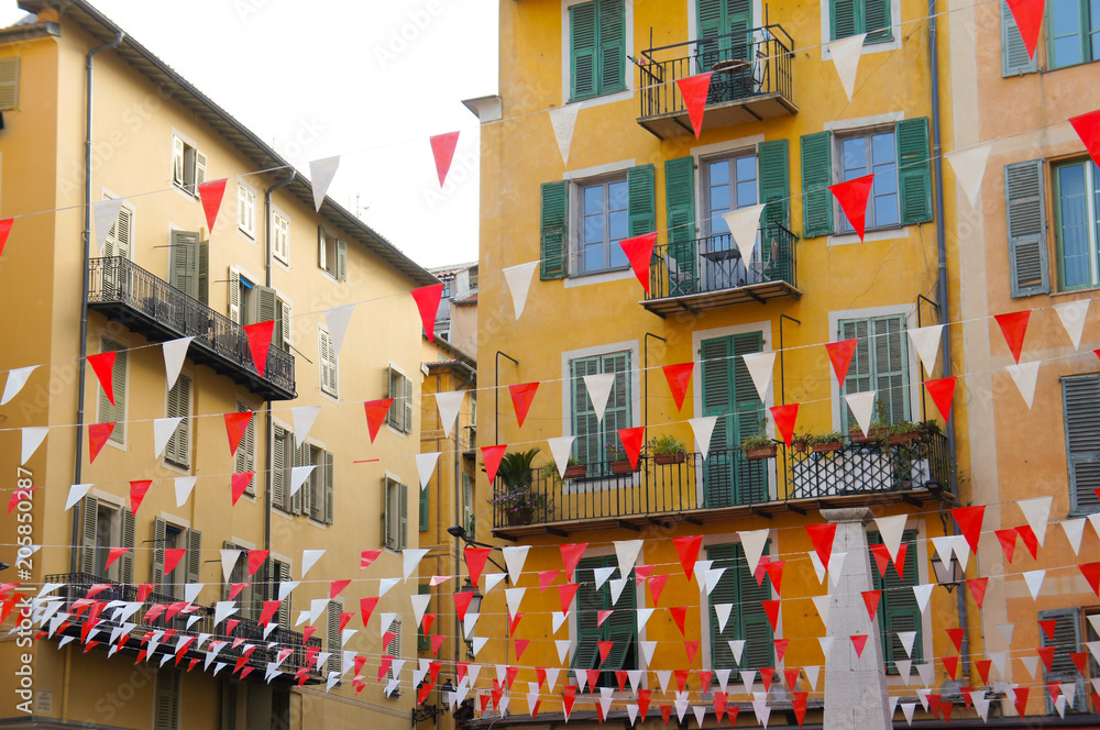  Streets of old town of Nice, France with white and red flags