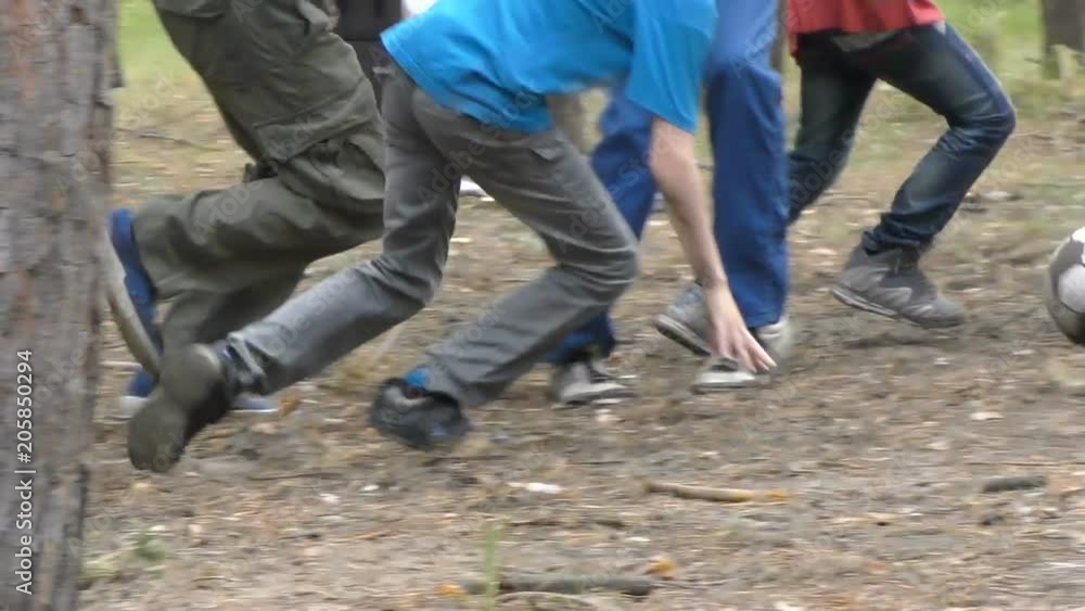 Boys playing football in the forest slow motion Boys playing football in the forest slow motion