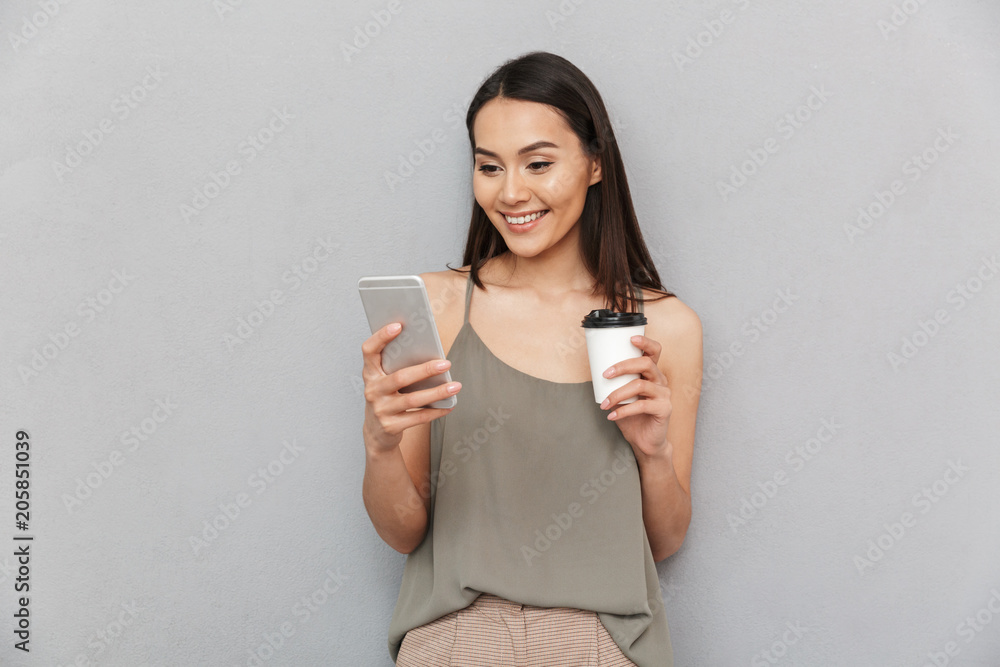Portrait of a smiling asian woman holding takeaway coffee Portrait of a smiling asian woman holding takeaway coffee