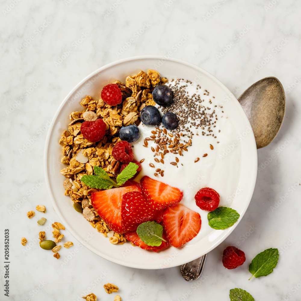 Bowl of homemade granola with yogurt and fresh berries