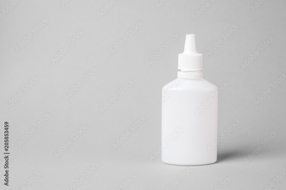 Spray for the nose in a white plastic bottle on a gray background. Aerosol from the common cold or allergy. mock-up Spray for the nose in a white plastic bottle on a gray background. Aerosol from the common cold or allergy. mock-up