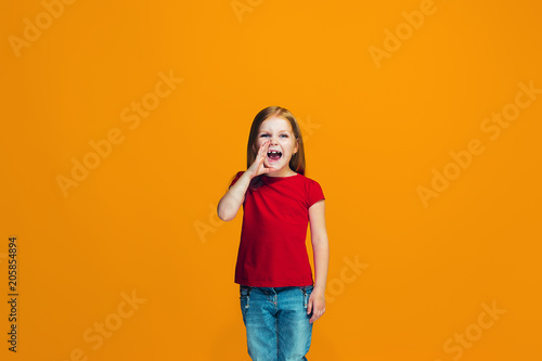Isolated on pink young casual teen girl shouting at studio