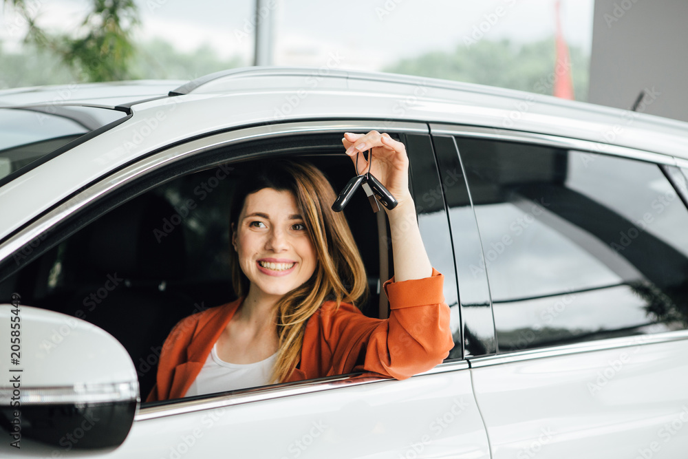 Woman buying a new car in the car dealership saloon. Stock-Foto | Adobe ...