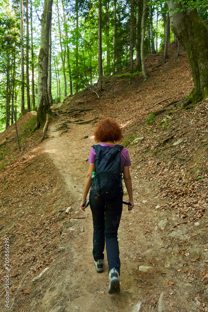 Woman hiking on a mountain trail Woman hiking on a mountain trail