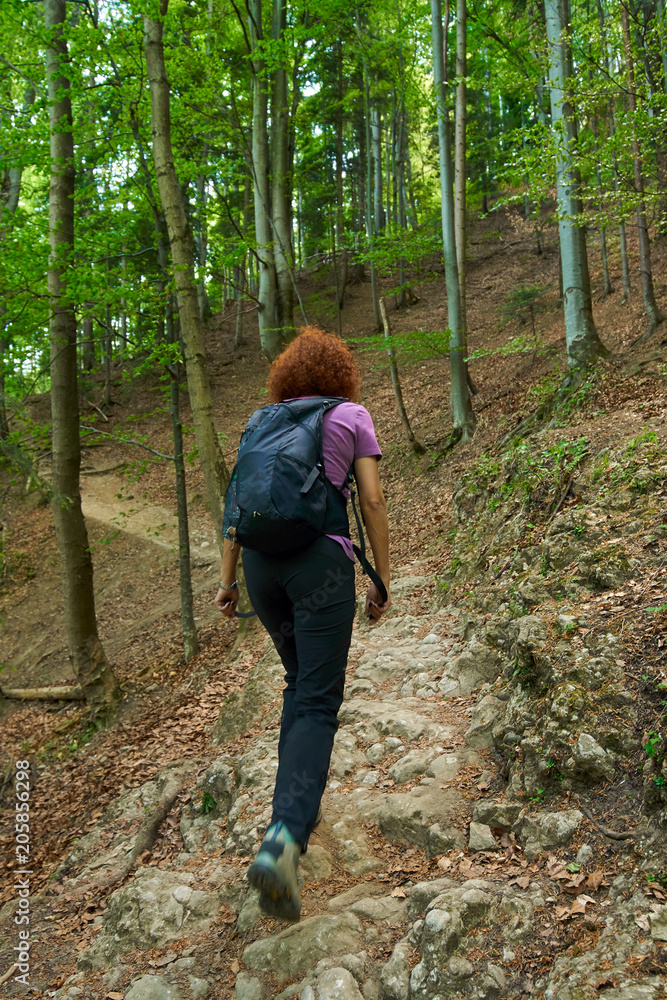 Woman hiking on a mountain trail Woman hiking on a mountain trail