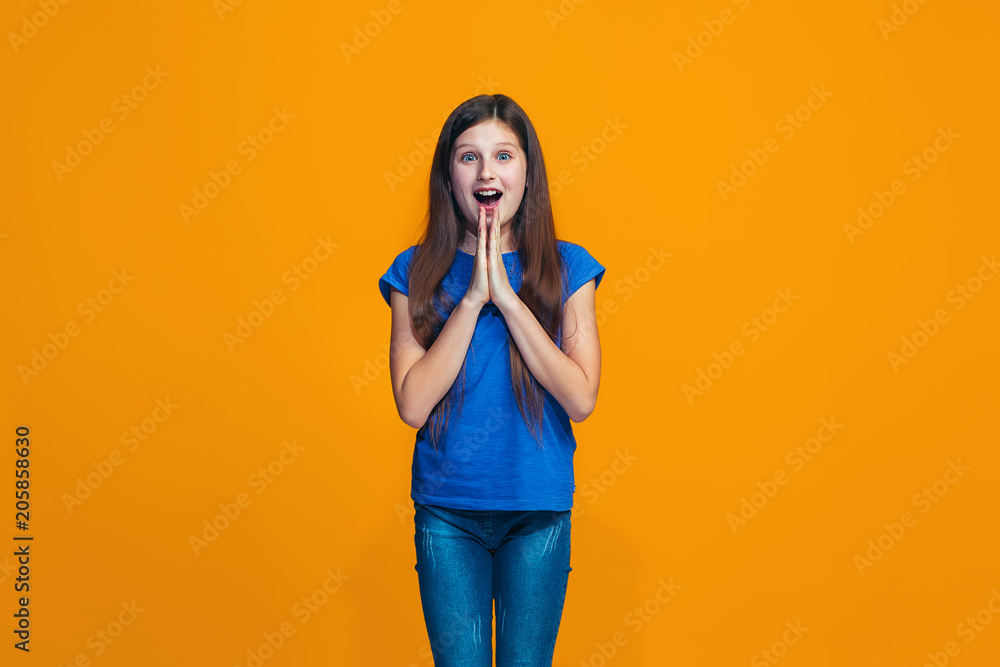 Beautiful teen girl looking suprised isolated on orange Beautiful teen girl looking suprised isolated on orange