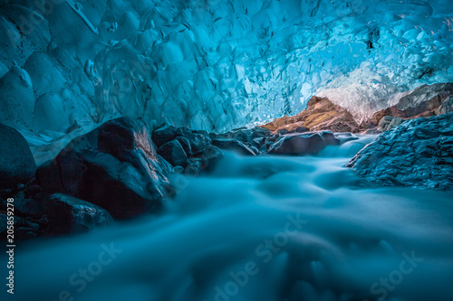 grotta di ghiaccio azzurro con ruscello sottostante Islanda Europa photo