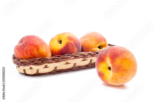 Single ripe peach fruit and several in basket isolated on white background.
