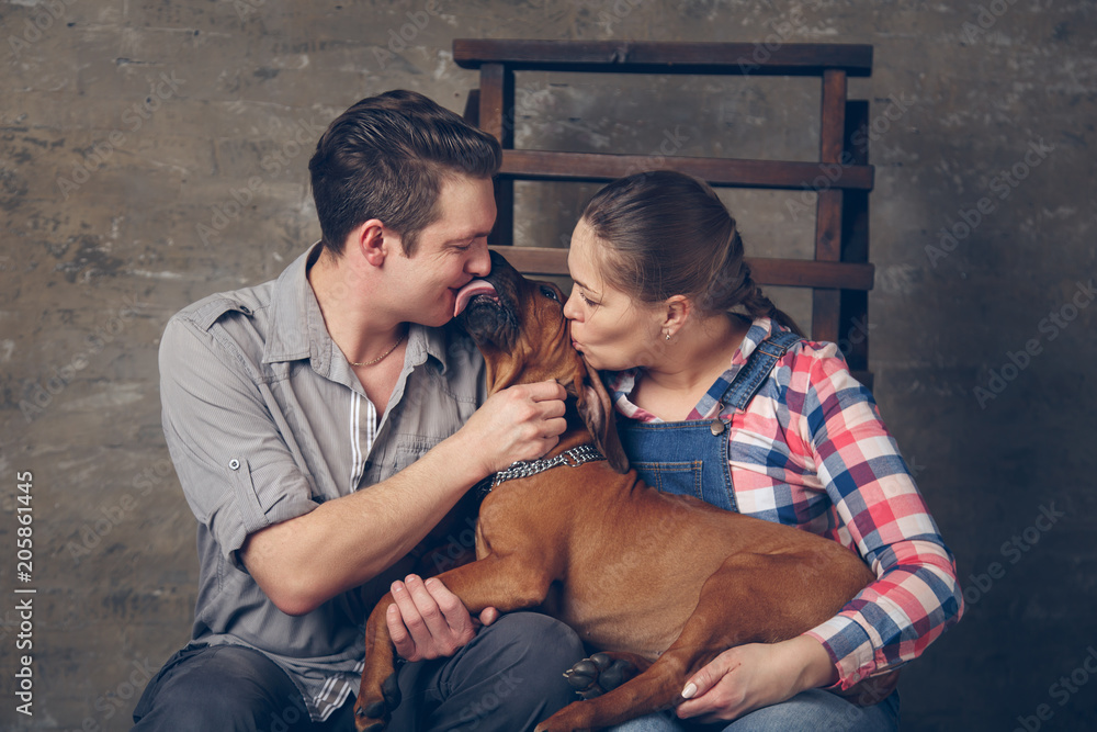 Young happy family playing with their puppy. Young happy family playing with their puppy.