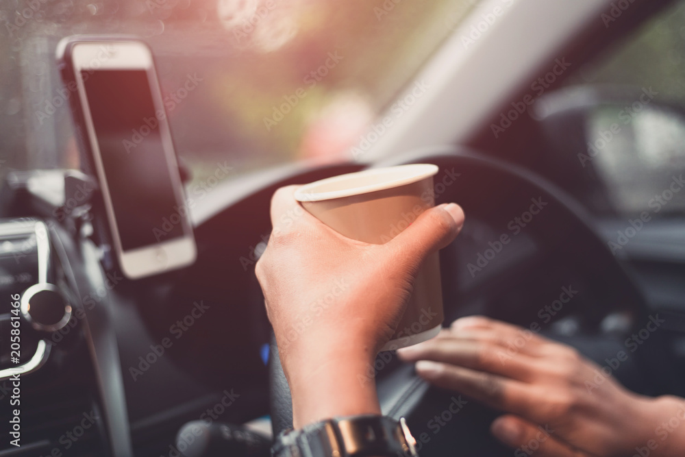 transportation and vehicle concept - driver drinking coffee while driving the car transportation and vehicle concept - driver drinking coffee while driving the car