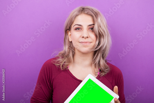 Young blonde woman with a PC tablet in her hands. The tables is with green screen