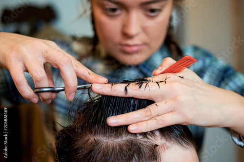 Master cuts hair and beard of men in the barbershop