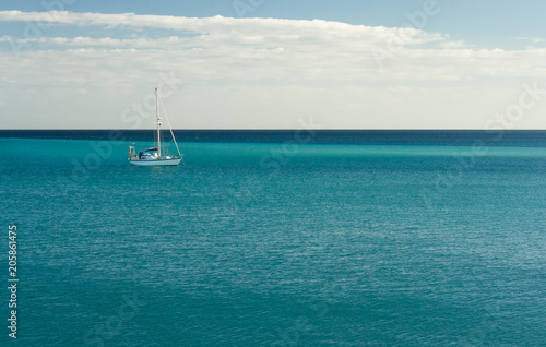 Blue Atlantic Ocean with white yacht on the horizon © Inna