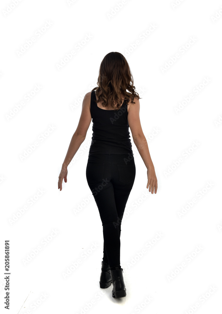 full length portrait of brunette girl wearing black singlet, jeans jeans and boots. standing pose, with back view. isolated on white studio background. full length portrait of brunette girl wearing black singlet, jeans jeans and boots. standing pose, with back view. isolated on white studio background.