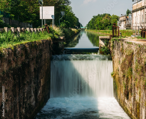 Cascade on a lock at the Naviglio Pavese  a canal that connects the city of Milan with Pavia  Italy 