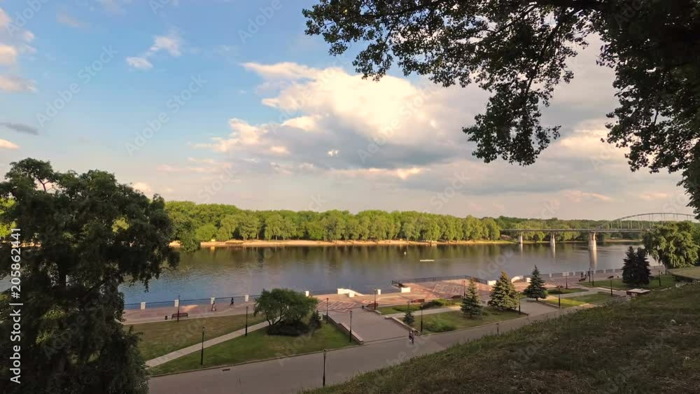 GOMEL, BELARUS - May 15, 2018: Embankment of the Sozh River and the pedestrian bridge. GOMEL, BELARUS - May 15, 2018: Embankment of the Sozh River and the pedestrian bridge.