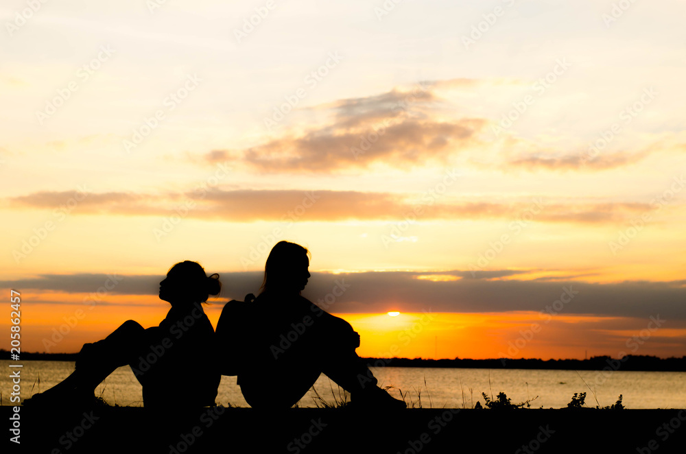 The silhouette of a woman is talking lazily in the evening when the sun is falling. The silhouette of a woman is talking lazily in the evening when the sun is falling.