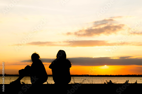 The silhouette of a woman is talking lazily in the evening when the sun is falling.