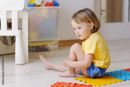 The kid plays with massage multi-colored puzzles.