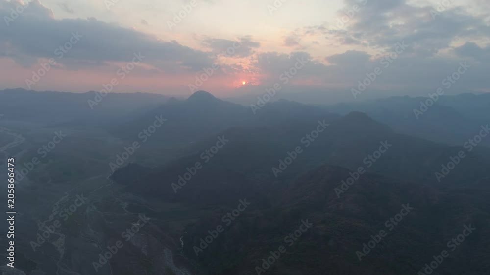 Aerial view sunset in mountain valley along which the river flows, surrounded by mountains covered with forest. Pinatubo, Cordillera region. Luzon, Philippines. Mountain landscape. Aerial view sunset in mountain valley along which the river flows, surrounded by mountains covered with forest. Pinatubo, Cordillera region. Luzon, Philippines. Mountain landscape.