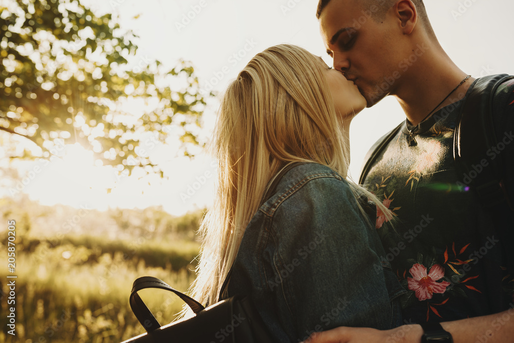 Φωτογραφία Close up portrait of a amazing young couple kissing and embracing in their vacation time against sunset