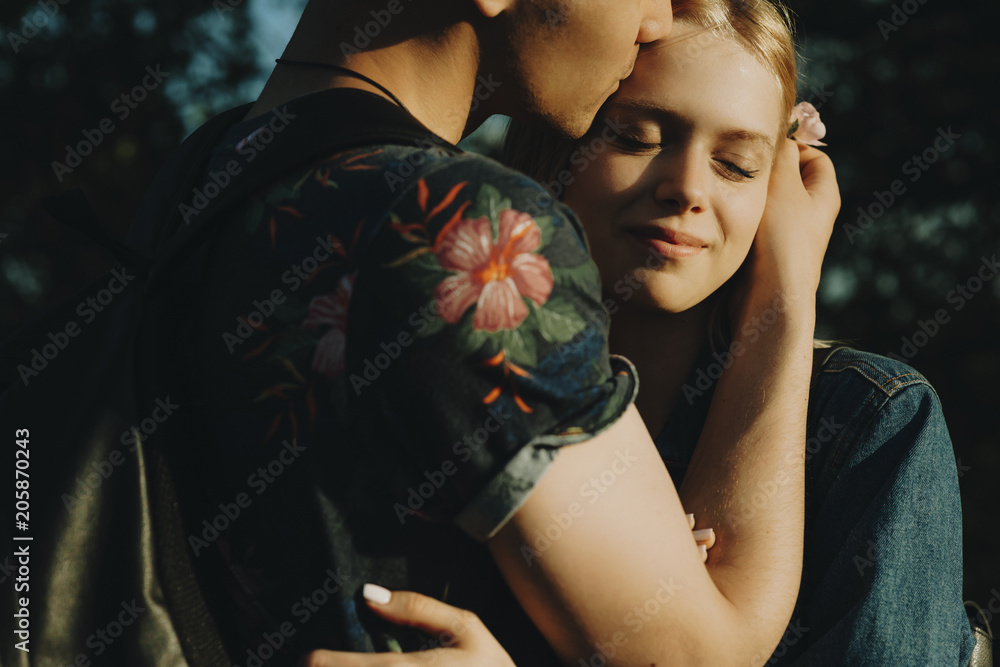 Close up portrait of a handsome couple embracing where man is putting a  flower in girls hair while she is smiling with closed eyes. Stock Photo |  Adobe Stock