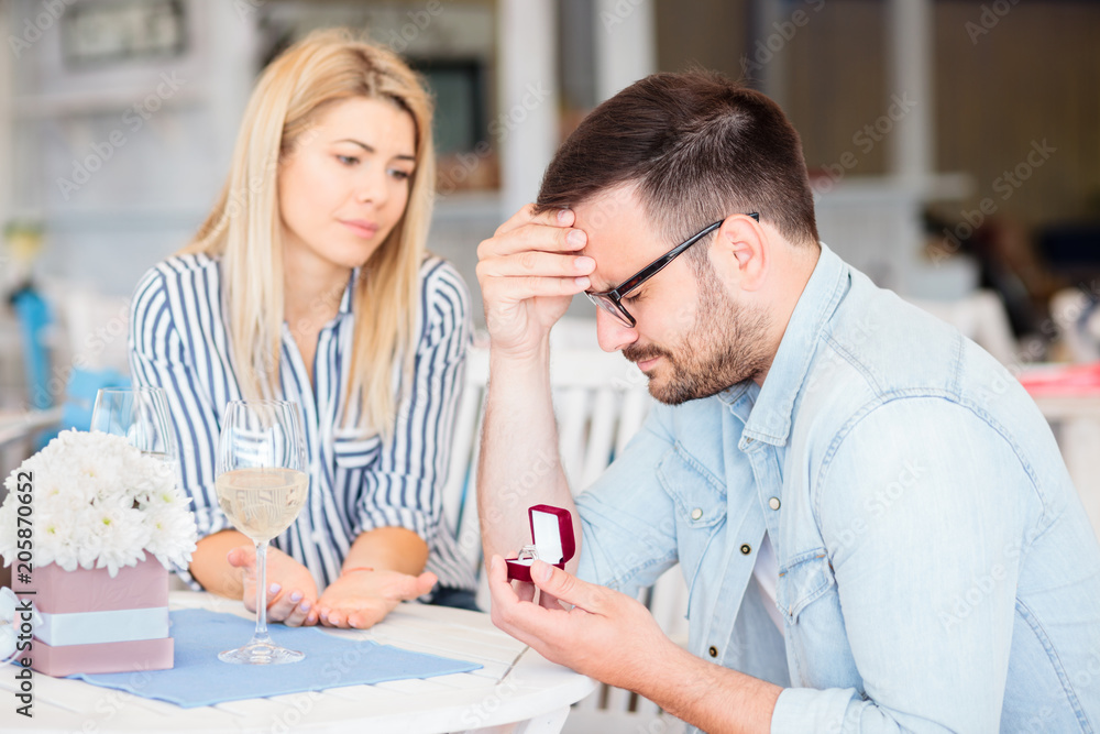 Fototapeta premium Disappointed young man is sad after his girlfriend rejected his marriage proposal.