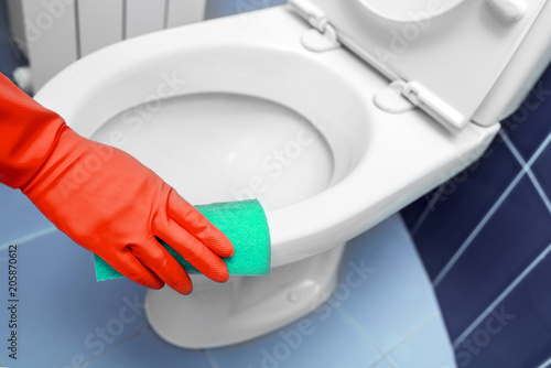 Hand wipes the toilet. photo