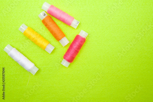 Multicolored thread coils red pink yellow white on green background
