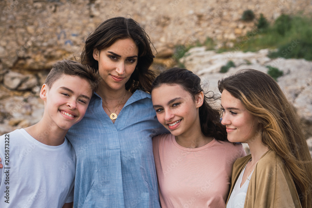 Group of teenagers looking at the camera together in summer Group of teenagers looking at the camera together in summer