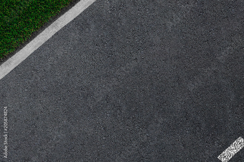 the asphalt which is smoothly passing to a white border and a green grass