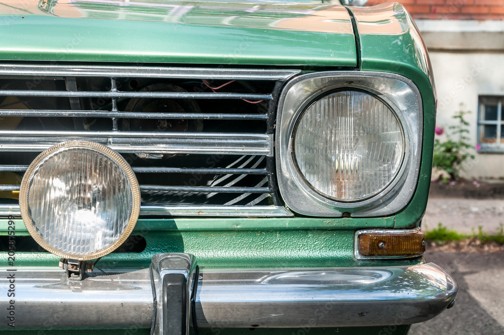 Old timer classic green car front headlight