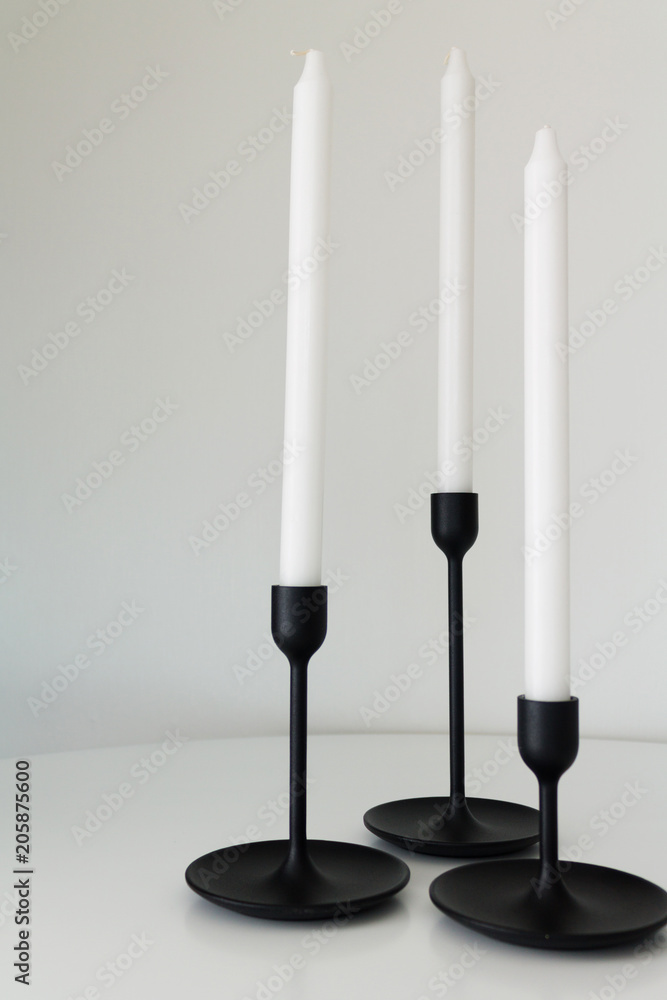 white candles black candlesticks three white candles black candlesticks three