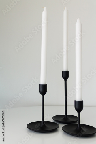 white candles black candlesticks three