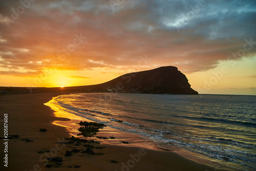 Fantastic sunset by the sea. Last rays of the setting sun on the ocean beach. Evening at the resort. Early morning by the sea, sunrise and mountains, rocks. The beauty of wildlife.