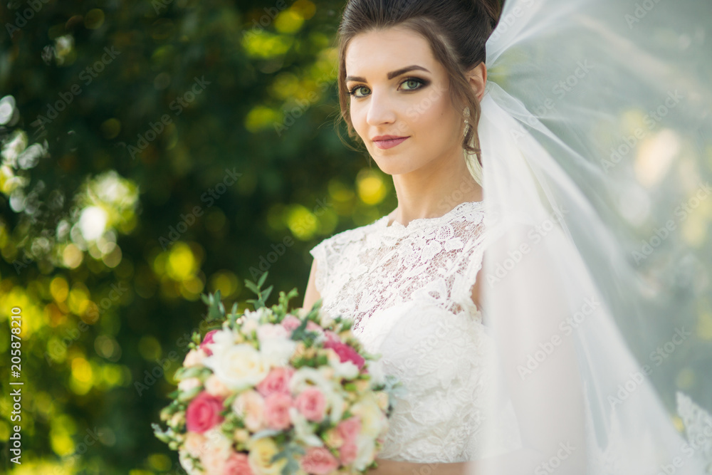 Beautiful bride hold a bouquet in hands. Happy bride smile to the photographet Beautiful bride hold a bouquet in hands. Happy bride smile to the photographet