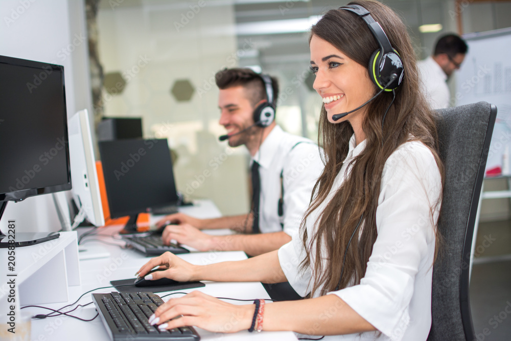 Helpline operators with headphones working in call centre Helpline operators with headphones working in call centre