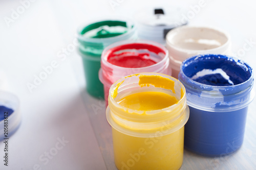 Fototapeta Open jars of gouache on white background