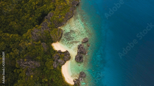 Tropical lagoon with turquoise water and white sand. Beautiful beach. Tropical bay in El Nido. Aerial view: bay and the tropical island. Seascape: mountains, ocean. Philippines, El Nido. Travel