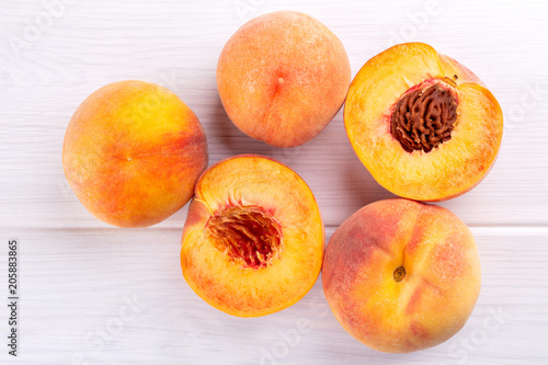 Ripe peaches close-up on a white wooden background.