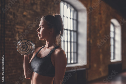 Young girl with dumbbells in the loft
