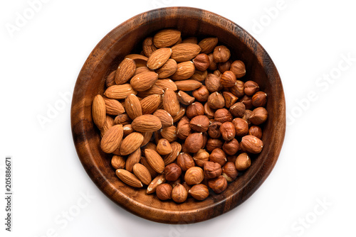 Almond and hazelnuts in wooden bowl, isolated on white- Nuts series