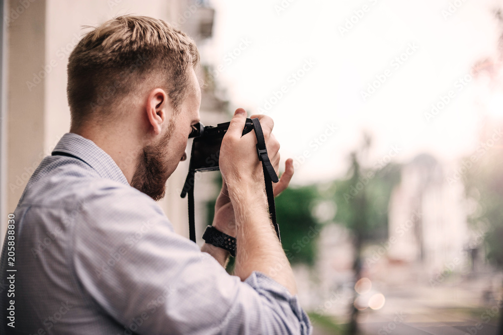 young male photographer with a mirrorless camera. young male photographer with a mirrorless camera.