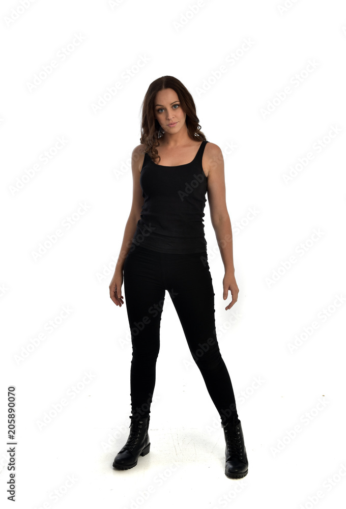full length portrait of brunette girl wearing black singlet, jeans jeans and boots. standing pose, isolated on white studio background. full length portrait of brunette girl wearing black singlet, jeans jeans and boots. standing pose, isolated on white studio background.