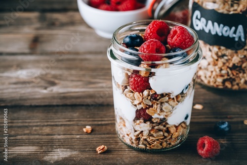 Obraz na plátně Healthy blueberry and raspberry parfait with greek yogurt in glass mason jar on