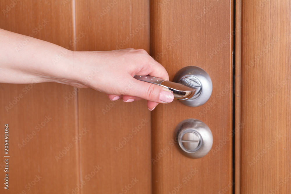 female hand hold handle of wood door female hand hold handle of wood door