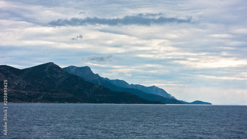 Dramatic clouds over Aegean sea with Pelion mountain in background, Greece Dramatic clouds over Aegean sea with Pelion mountain in background, Greece