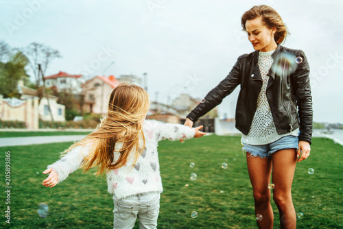 Mother with her little daughter have fun in the park