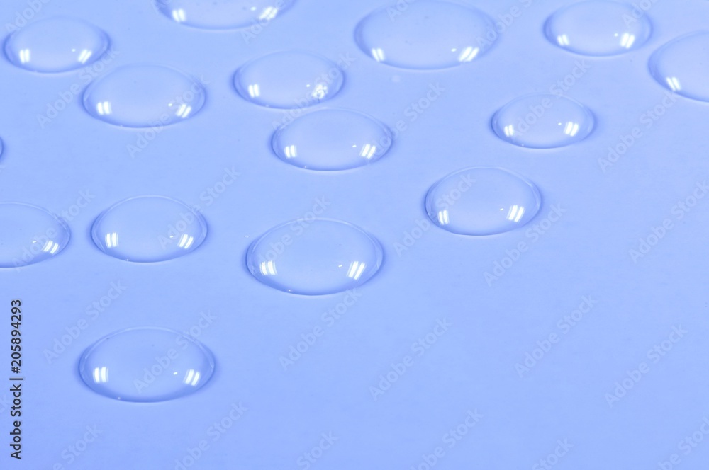 Transparent water drops on blue background.